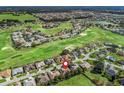 Aerial view of community showcasing a golf course, lake, and many homes at 17180 Se 115Th Terrace Rd, Summerfield, FL 34491