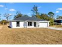 New construction home features a white exterior, gray roof and a two-car garage at 202 Shannon Ln, Lady Lake, FL 32159