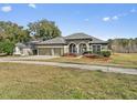 Attractive home showcasing a three-car garage, well-maintained lawn, and inviting curb appeal at 225 Sutherland Ct, Apopka, FL 32712