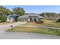 Lovely home boasting a three-car garage, manicured shrubs, and lush green lawn at 225 Sutherland Ct, Apopka, FL 32712