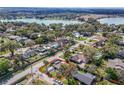 Aerial view of a single story home with lake views, featuring a well-maintained lawn and carport at 2384 Orange Capital Ct, Eustis, FL 32726