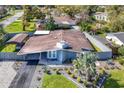 Aerial view of a single story home featuring a well-maintained lawn, carport, and elegant landscaping at 2384 Orange Capital Ct, Eustis, FL 32726