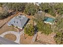 This aerial view shows the property's layout with the house, pool, and additional outbuildings at 24429 Adair Ave, Sorrento, FL 32776