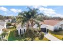 One-story house with white siding, dark garage door, and palm trees at 25324 Hibiscus St, Leesburg, FL 34748