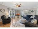 Inviting living room with plush seating, area rug, ceiling fan and view to sun room at 25547 Belle Helene, Leesburg, FL 34748