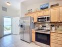 Stainless steel appliances and light wood cabinets in kitchen at 2849 Leicester Ter, The Villages, FL 32162