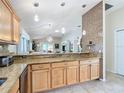 Kitchen with granite countertops and light wood cabinets at 2849 Leicester Ter, The Villages, FL 32162