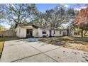 Front view of a charming ranch home with a spacious driveway at 307 Park Ave, Groveland, FL 34736