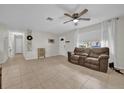 Inviting living room with a neutral color palette, ceiling fan, and ample natural light at 307 Park Ave, Groveland, FL 34736