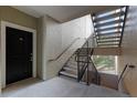 Condo building stairwell with a black front door and concrete stairs at 3480 Soho St # 206, Orlando, FL 32835