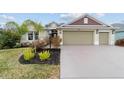 House exterior with a three-car garage and well manicured lawn at 3769 Causey Ct, The Villages, FL 32163