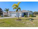 Two-car garage, palm trees, and expansive lawn at 4127 Arlington Ridge Blvd, Leesburg, FL 34748