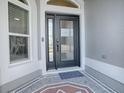 Front door with decorative glass panel, modern hardware, and a textured exterior finish at 4774 Cosentino Ct, The Villages, FL 32163