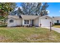 Inviting single-story home with a green lawn, attached garage, and pleasant front facade at 5338 Tigers Tail, Leesburg, FL 34748