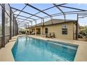 Relaxing backyard swimming pool with screened enclosure and covered patio seating area at 5424 Donahe Path, The Villages, FL 32163