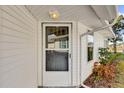 Front door view with a screen door and surrounding landscaping at 5513 Shriver St, Leesburg, FL 34748