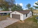 White single story home with brown garage door and paved driveway at 819 Bolivar St, The Villages, FL 32159