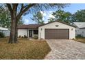 Single story home with brown garage door and paved driveway at 819 Bolivar St, The Villages, FL 32159