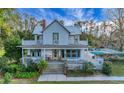 Charming two-story home with a wrap-around porch and an inviting in-ground pool at 9210 County Road 48, Yalaha, FL 34797