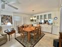 Bright dining area featuring a wooden dining table set and cabinet space, illuminated by a stylish chandelier at 113 Willow Ln, Leesburg, FL 34748