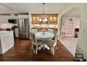 Cozy dining area featuring a round table, elegant chairs, a decorative hutch, and hardwood flooring at 122 Tamarisk Way, Leesburg, FL 34748
