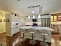 Modern kitchen features white cabinetry, stainless steel appliances, a large island with seating, and stylish pendant lighting at 122 Tamarisk Way, Leesburg, FL 34748