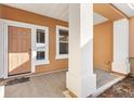 Inviting front porch with neutral tones and a view of the home's entrance, featuring a solid front door at 12455 Se 92Nd Ter, Summerfield, FL 34491