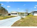 Inviting single-story home with a covered carport, complemented by a spacious driveway and lush green lawn at 1616 Bayhill Dr, The Villages, FL 32159