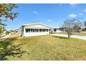 Well-kept single-story home featuring a screen room and green lawn, providing a comfortable living environment at 1616 Bayhill Dr, The Villages, FL 32159