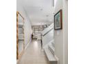 Inviting hallway with tile flooring, a decorative mirror, and a staircase leading to the upper level at 17523 Promenade Dr, Clermont, FL 34711