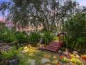 Lush backyard pond with red footbridge and stone path under mature tree at 17652 Se 120Th Ter, Summerfield, FL 34491