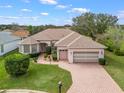 Well-maintained home with a brick driveway, lush lawn, and mature landscaping at 17652 Se 120Th Ter, Summerfield, FL 34491