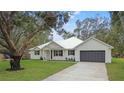 Modern farmhouse exterior with metal roof and dark gray garage door at 18315 Dells Cv, Groveland, FL 34736