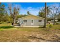 Backyard with an open patio and a well-maintained lawn, perfect for outdoor entertaining at 18415 County Road 33, Groveland, FL 34736
