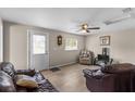 Cozy living room with a ceiling fan, wood-look flooring, and comfortable leather seating at 18415 County Road 33, Groveland, FL 34736