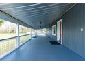 Long covered porch features painted wood and metal roof with views of the grounds at 2685 Cr 776, Webster, FL 33597