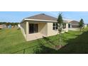 Exterior rear view featuring the home's backyard, patio, and sliding glass doors at 2854 Supermarine Rd, Tavares, FL 32778