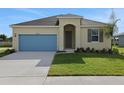 Charming single-story home with a well-manicured lawn, blue garage door and neutral paint scheme at 2854 Supermarine Rd, Tavares, FL 32778