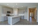 Modern kitchen with gray cabinets, stainless steel appliances, white countertops, and a center island at 2854 Supermarine Rd, Tavares, FL 32778