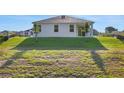 Expansive backyard with lush green grass surrounding a modern home with sliding glass doors at 2932 Supermarine Rd, Tavares, FL 32778