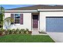 Home exterior featuring well-kept lawn, front entrance, and colorful window shutters at 2932 Supermarine Rd, Tavares, FL 32778