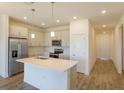 Well-lit kitchen featuring stainless steel appliances, a central island, and a stylish backsplash at 2932 Supermarine Rd, Tavares, FL 32778