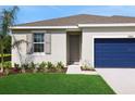 Inviting home with neatly landscaped front yard, neutral paint, and a striking blue garage door at 2950 Supermarine Rd, Tavares, FL 32778