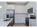 Close-up of kitchen with stainless steel appliances, quartz countertops, and white cabinets at 2950 Supermarine Rd, Tavares, FL 32778