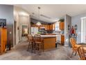 Open kitchen featuring an island with seating, light wood cabinetry, and neutral countertops at 3218 Woodridge Dr, The Villages, FL 32162