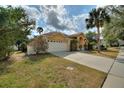 Well-manicured lawn and long driveway lead up to a two-car garage at 3310 Osprey Hill St, Clermont, FL 34714