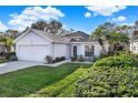 Single-story house with white exterior, attached garage, and well-manicured lawn at 509 Baytree Blvd, Tavares, FL 32778