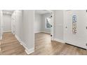 Bright foyer featuring modern flooring, white walls, and a decorative front door at 8264 Sw 128Th Ter, Dunnellon, FL 34432