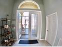 Welcoming foyer featuring tile flooring, display shelving, and natural light at 10177 Mainsail Dr, Oxford, FL 34484