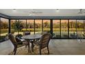 Enclosed sun room with wicker furnishings and panoramic lake views at 5449 Dray Dr, The Villages, FL 32163